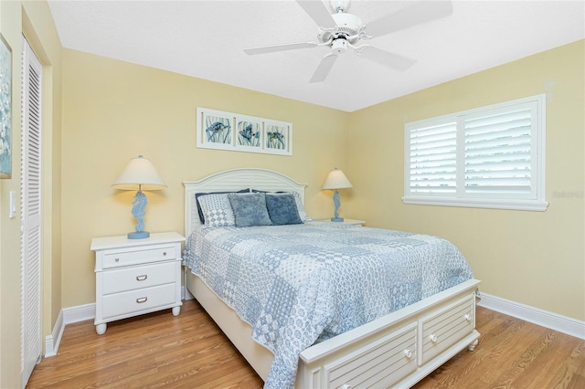 bedroom featuring a ceiling fan, baseboards, and light wood finished floors