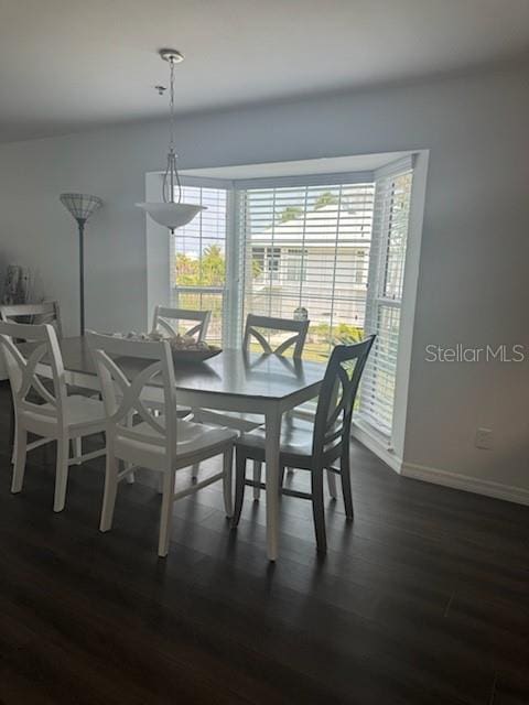 dining room with dark wood-style flooring and baseboards