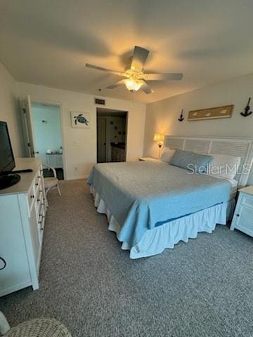 bedroom featuring visible vents, dark colored carpet, and a ceiling fan