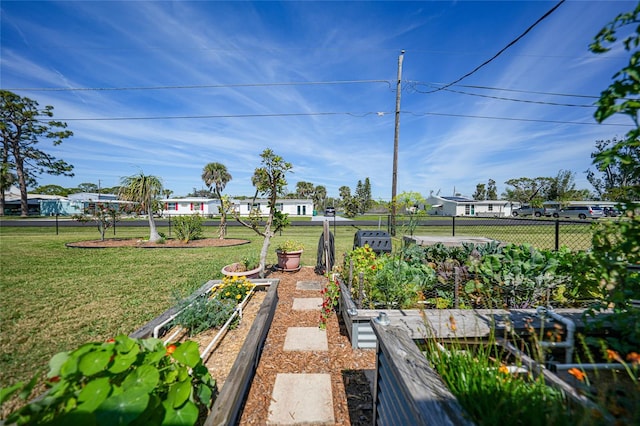 view of home's community featuring a residential view, a vegetable garden, fence, and a lawn