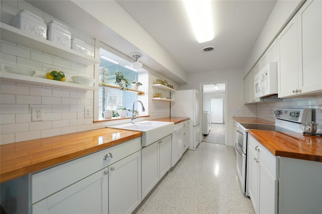 kitchen with white appliances, a sink, wood counters, white cabinets, and open shelves