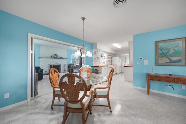 dining area featuring a brick fireplace, baseboards, and visible vents