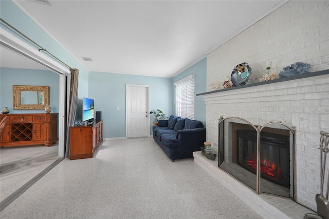 living room featuring light speckled floor, a brick fireplace, and visible vents