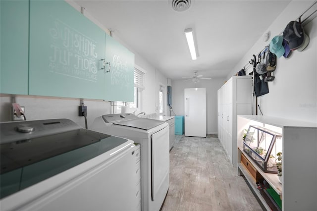 laundry area featuring visible vents, a ceiling fan, washer and dryer, light wood-type flooring, and cabinet space