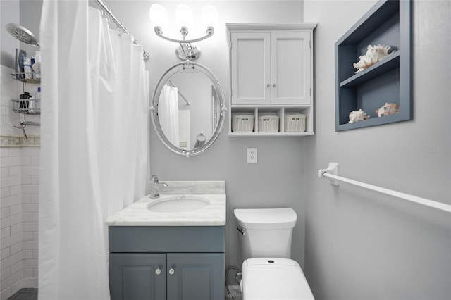 full bath featuring toilet, a tile shower, and vanity