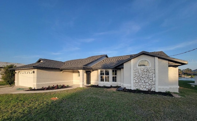 view of front facade featuring a front lawn, an attached garage, and stucco siding