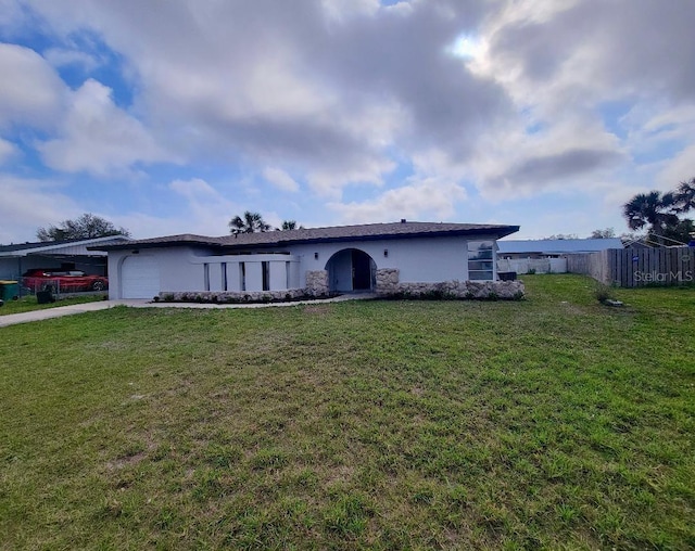 ranch-style home featuring stucco siding, a front yard, an attached garage, and fence