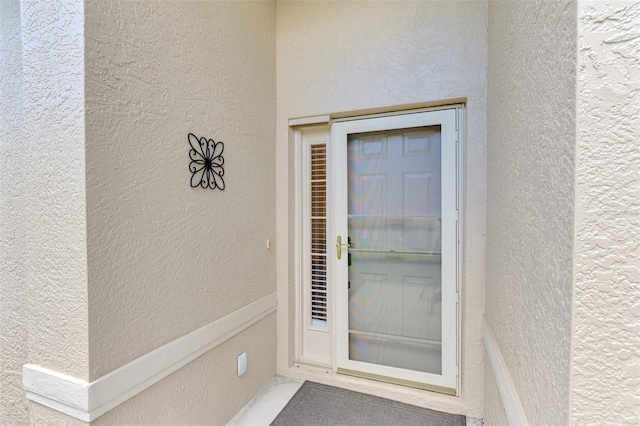 entrance to property featuring stucco siding