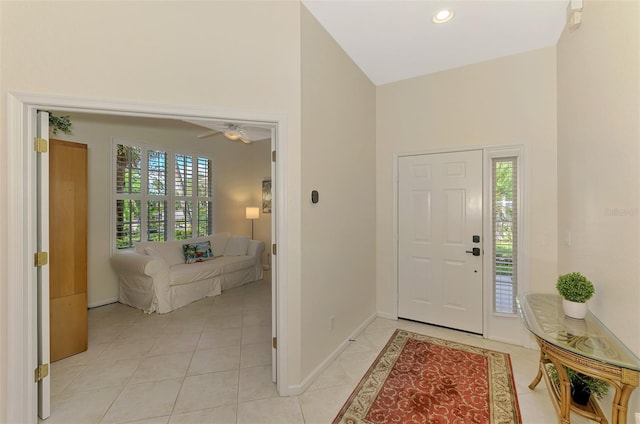 entryway with high vaulted ceiling, recessed lighting, light tile patterned flooring, and baseboards