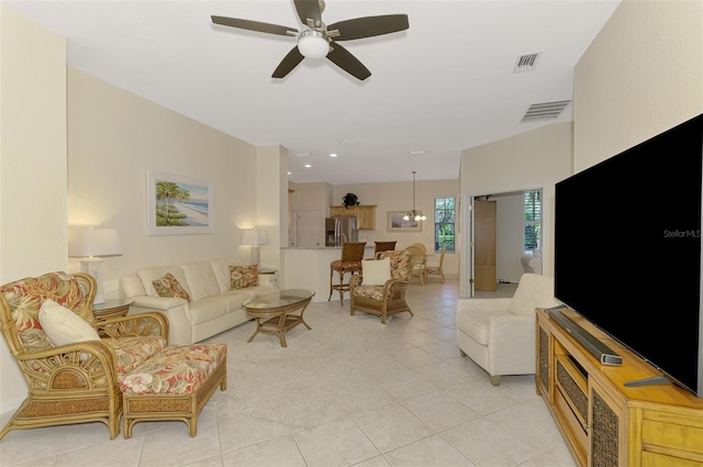 living area with a ceiling fan, visible vents, and light tile patterned floors