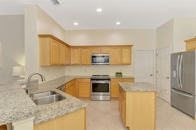 kitchen with light stone counters, visible vents, appliances with stainless steel finishes, a sink, and a peninsula