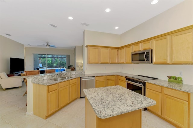 kitchen with light brown cabinets, stainless steel appliances, and a sink