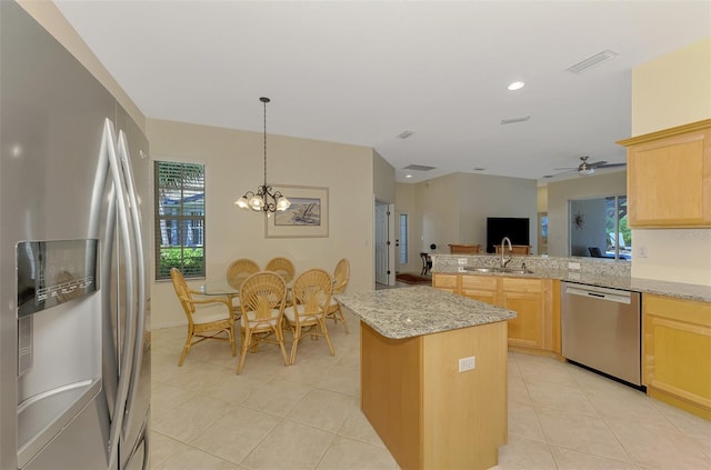 kitchen featuring a sink, stainless steel appliances, a peninsula, and light brown cabinets