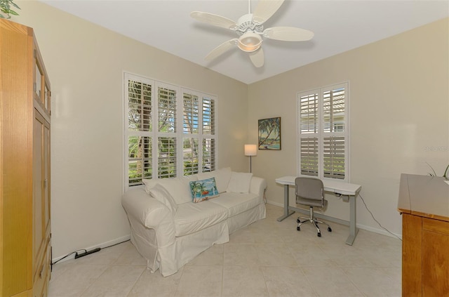 office area featuring a ceiling fan, baseboards, and light tile patterned floors