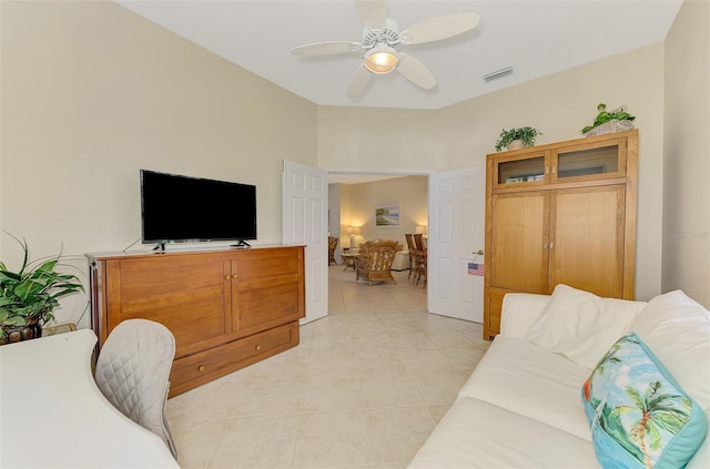 living room with visible vents, light tile patterned flooring, and a ceiling fan