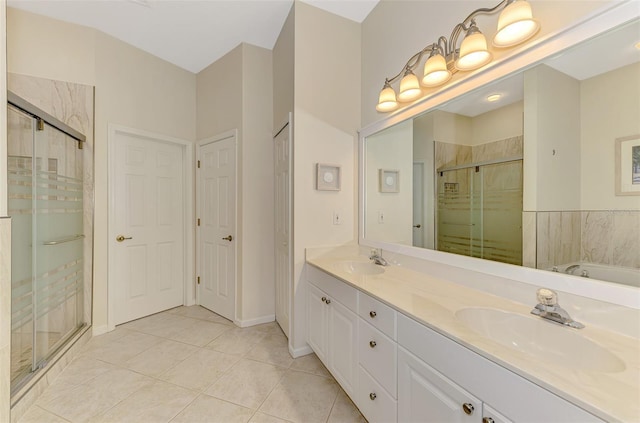 full bath with double vanity, a stall shower, a sink, and tile patterned floors