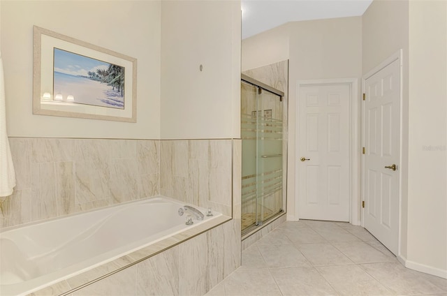 bathroom with a shower stall, a bath, and tile patterned floors