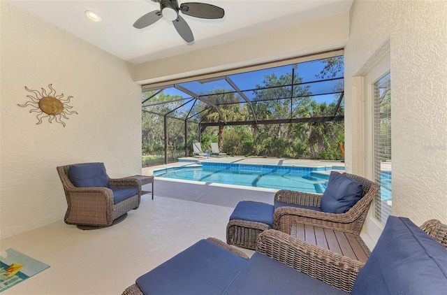 outdoor pool with ceiling fan, a patio area, and a lanai