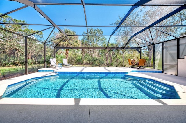 outdoor pool with glass enclosure and a patio area