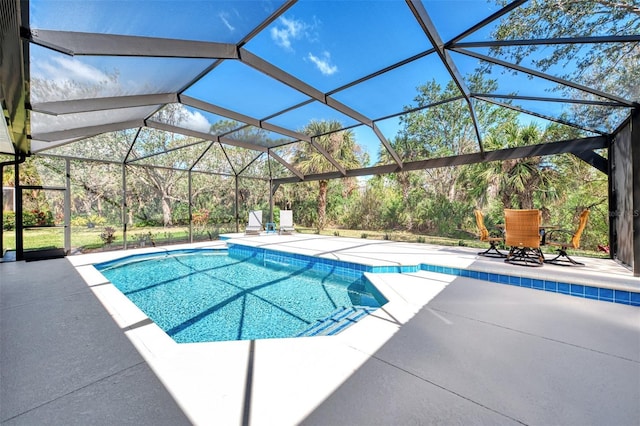 outdoor pool featuring glass enclosure and a patio