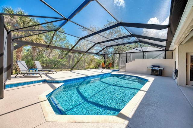 pool with glass enclosure, a patio, and area for grilling