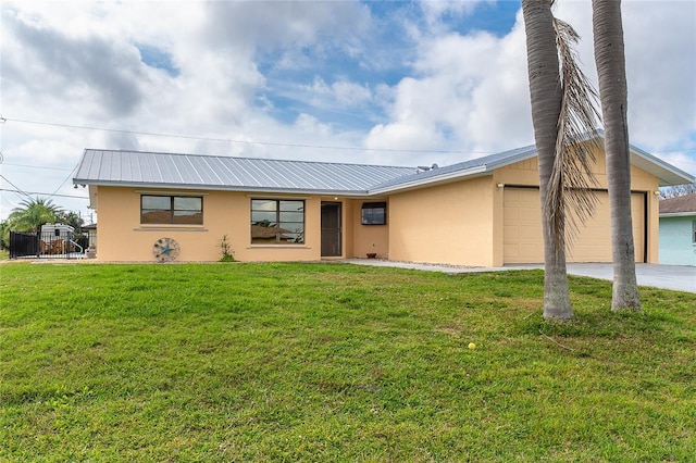 view of front of property with a front yard, metal roof, concrete driveway, and stucco siding