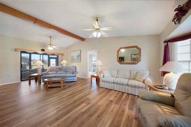 living room featuring lofted ceiling with beams, light wood finished floors, plenty of natural light, and baseboards