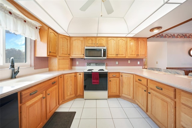 kitchen with black dishwasher, light countertops, stainless steel microwave, electric range, and a sink