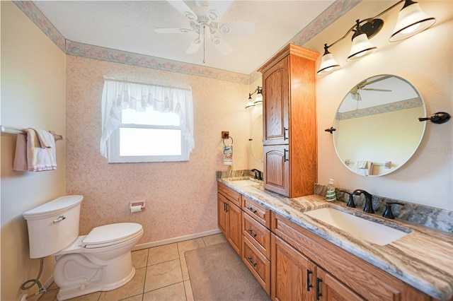 full bathroom with double vanity, tile patterned flooring, toilet, and a sink