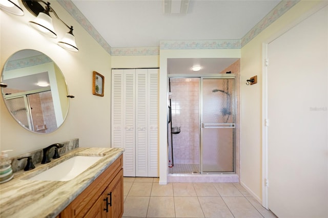 bathroom with a closet, visible vents, vanity, a shower stall, and tile patterned floors