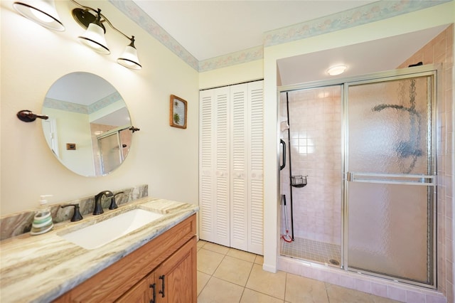 full bath with tile patterned floors, a shower stall, a closet, and vanity