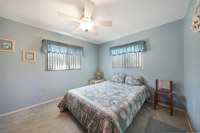 carpeted bedroom featuring ceiling fan, multiple windows, and baseboards