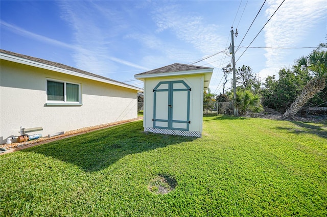 view of yard featuring a shed, an outdoor structure, and fence