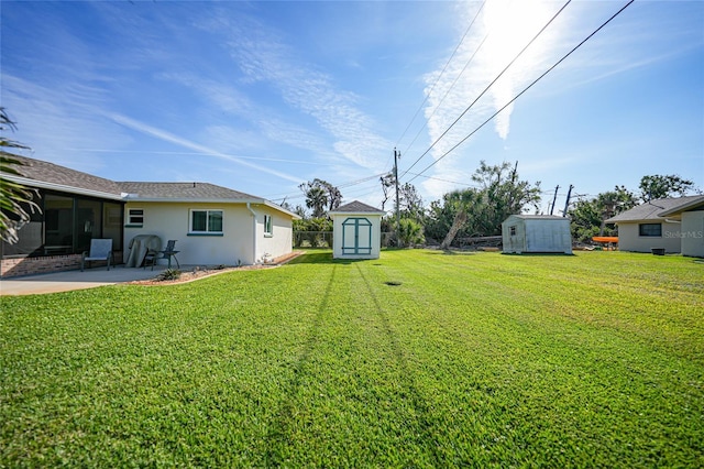 view of yard with a storage unit, a patio, and an outbuilding