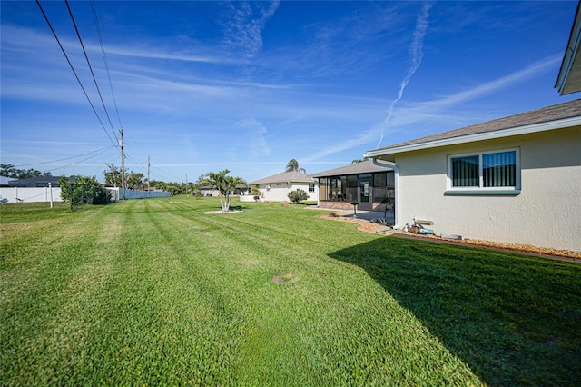 view of yard featuring a sunroom and fence