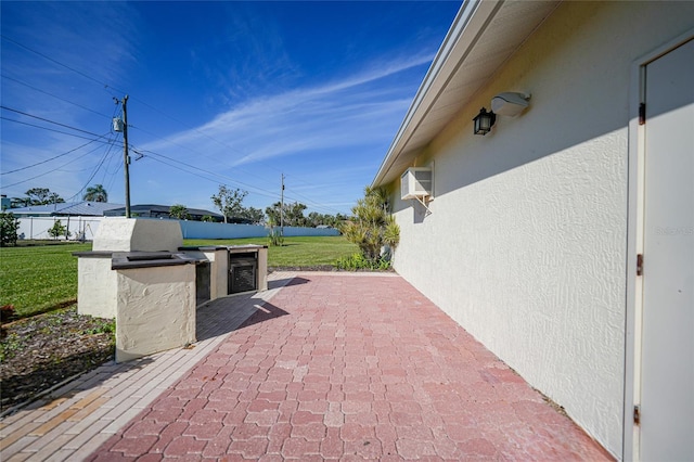 view of patio with a wall unit AC and fence