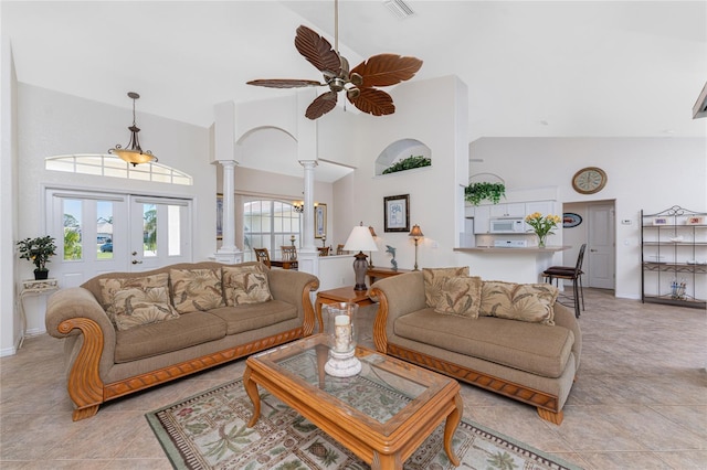 living room with high vaulted ceiling, visible vents, ornate columns, and a ceiling fan