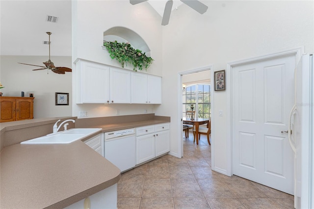 kitchen featuring light tile patterned flooring, white appliances, a towering ceiling, visible vents, and white cabinets