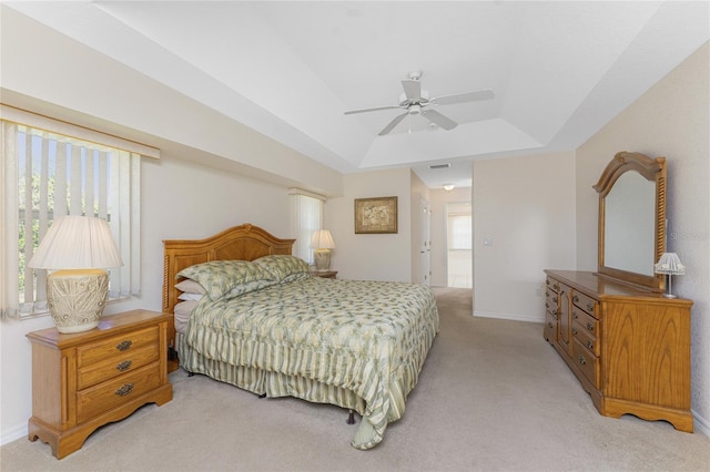 bedroom featuring light carpet, baseboards, visible vents, and a raised ceiling