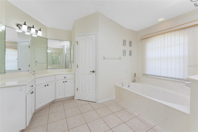 full bathroom featuring tile patterned flooring, a garden tub, vanity, and baseboards