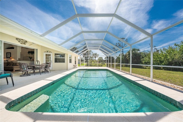 outdoor pool featuring glass enclosure and a patio