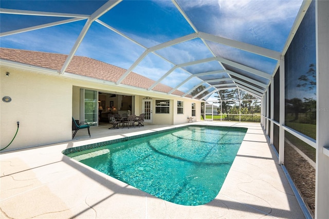 pool with glass enclosure and a patio area