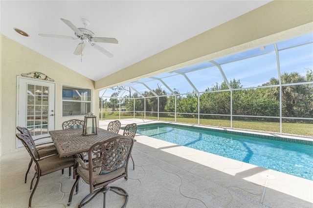 outdoor pool featuring glass enclosure, a patio area, and a ceiling fan