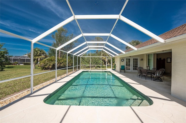 outdoor pool featuring french doors, a patio area, a lawn, and a lanai