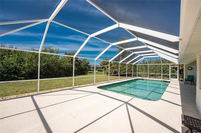 pool with glass enclosure, a patio, and a lawn