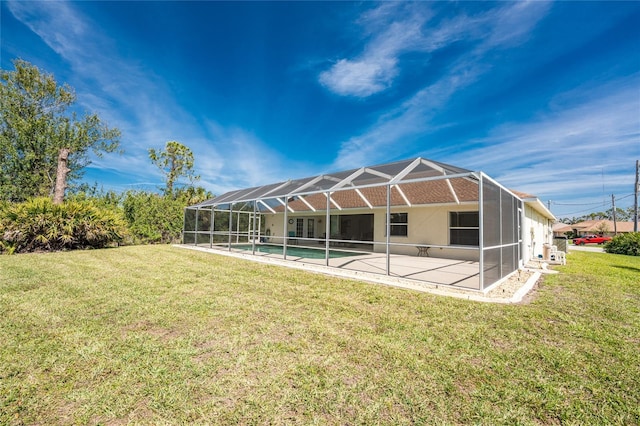 back of house with a lanai, an outdoor pool, a lawn, and a patio