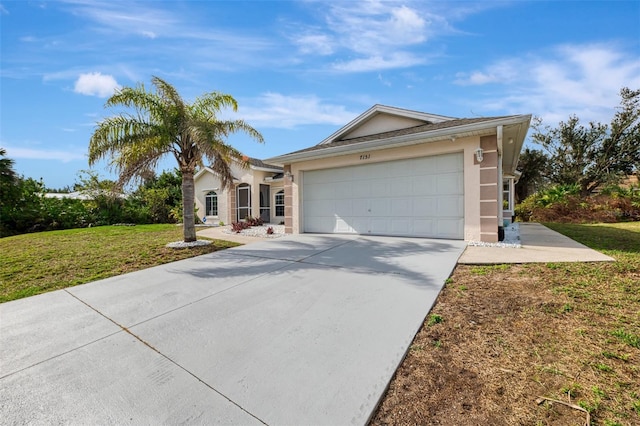 single story home featuring a garage, driveway, a front lawn, and stucco siding