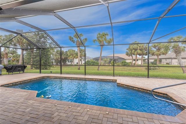 outdoor pool with glass enclosure, a yard, and a patio area