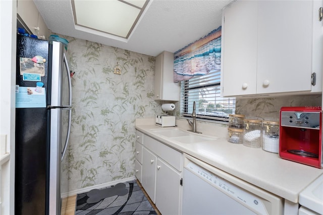 kitchen with wallpapered walls, light countertops, dishwasher, and freestanding refrigerator