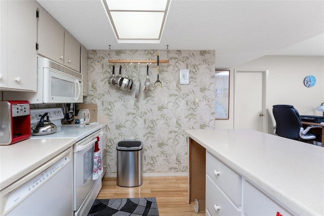 kitchen featuring light countertops, light wood-style floors, white appliances, baseboards, and wallpapered walls